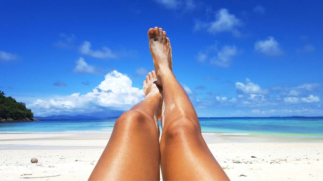 Tanned legs on a sandy beach